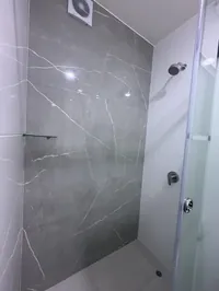 Ducha del baño compartido con pared de mármol gris