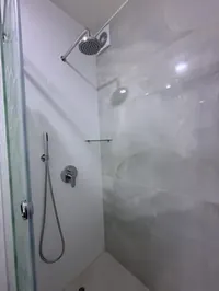 Ducha del baño propio con pared de mármol gris y ducha teléfono